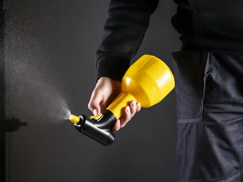 A technician holding a pest control sprayer